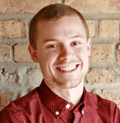 Student in red, collared shirt smiling at camera